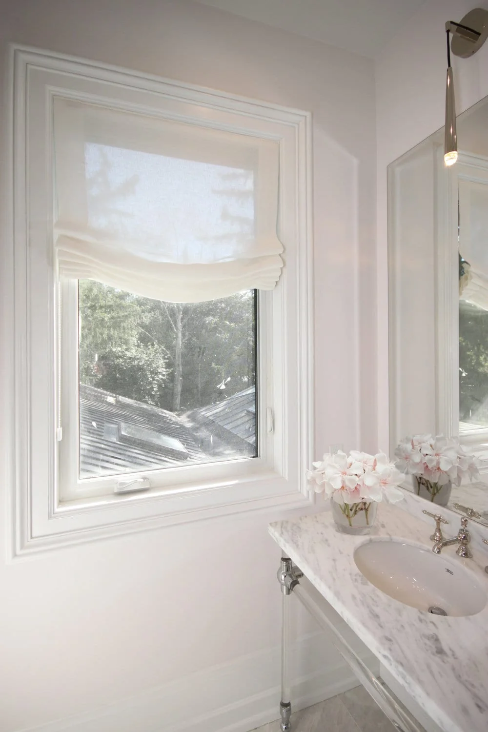 Sheer white relaxed roman shade in a bathroom