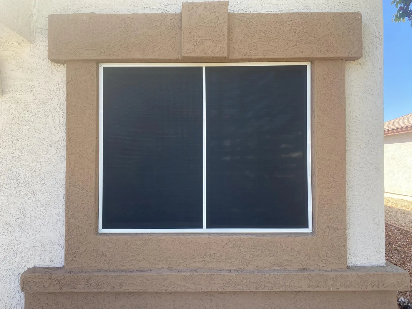 Full Window Coverage, a two-panel sun screen set square in a stucco opening covering the glass corner to corner with no gaps