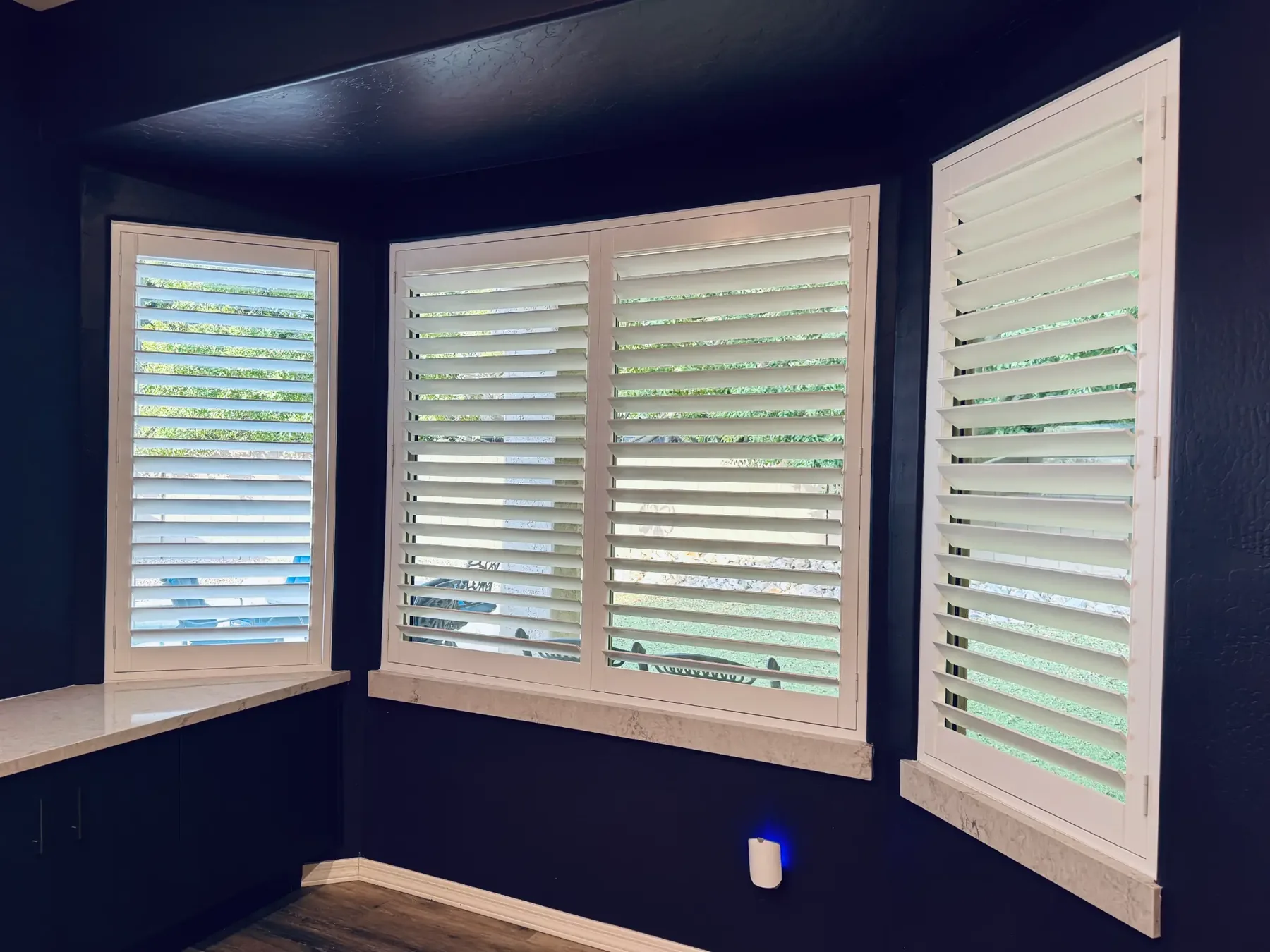 Curved bay window shutters, three panels following the angle of the wall