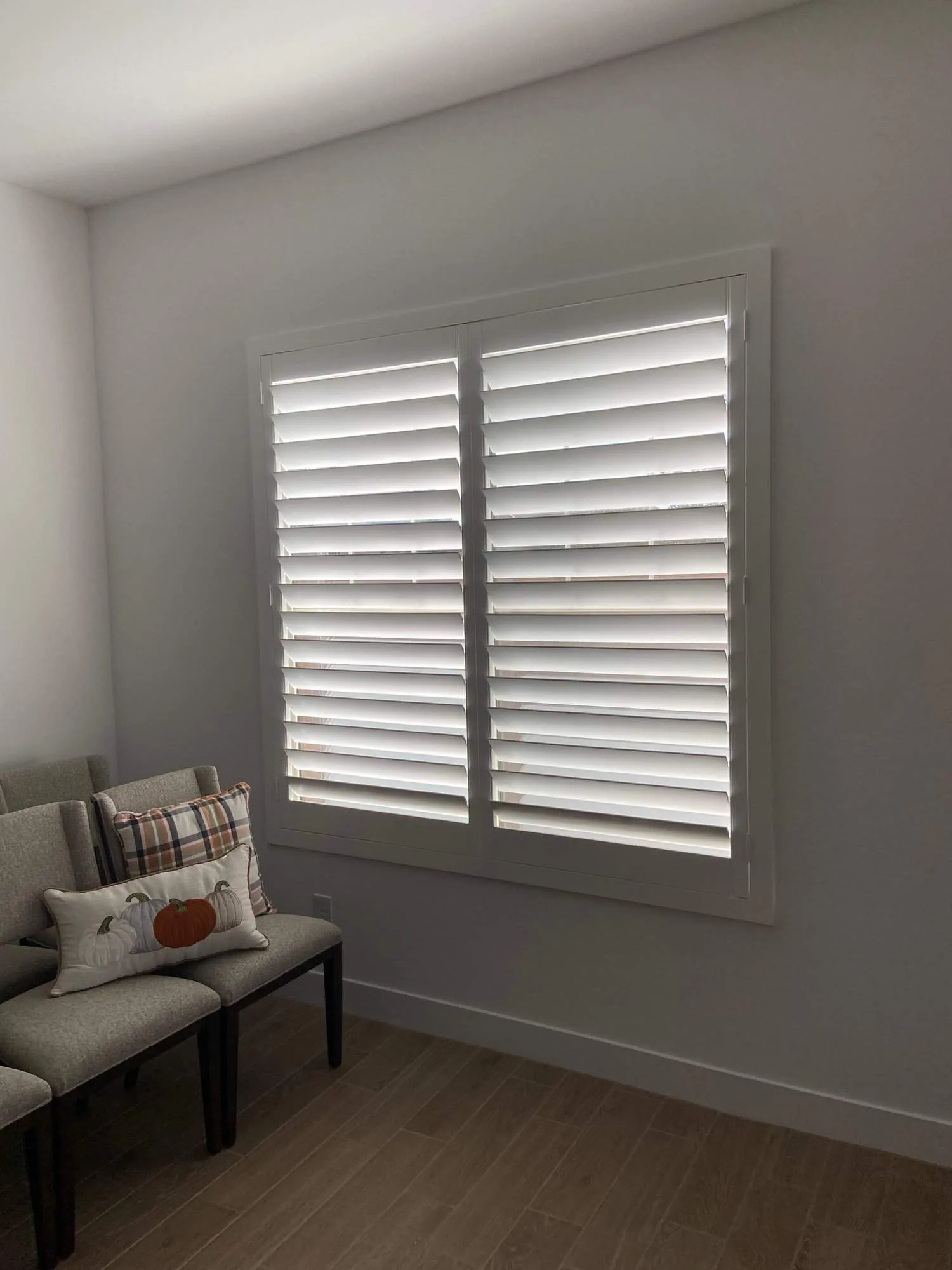 White plantation shutters in a neutral sitting room